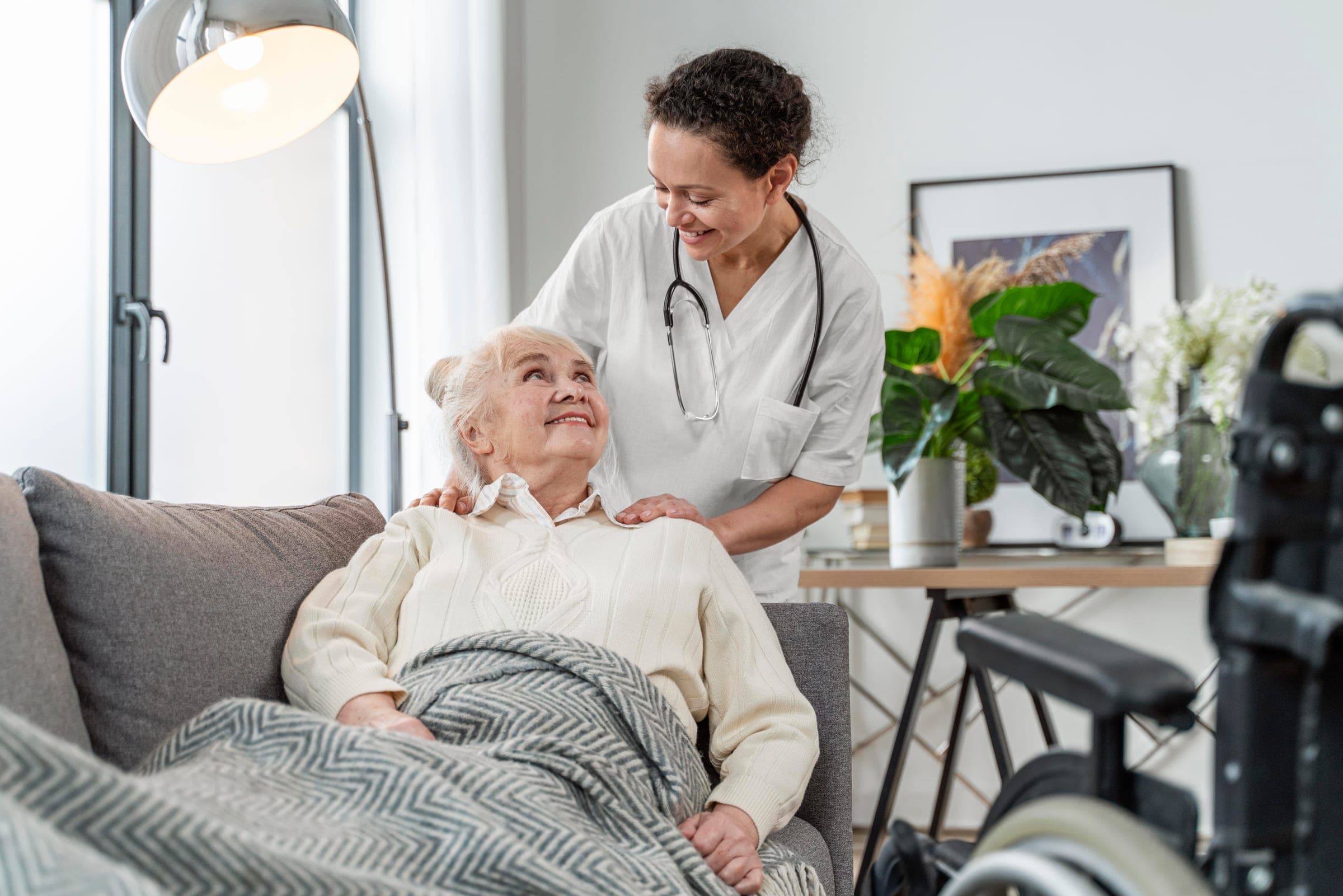 A Hamsa caregiver and a senior client sharing a quiet moment on the couch.
