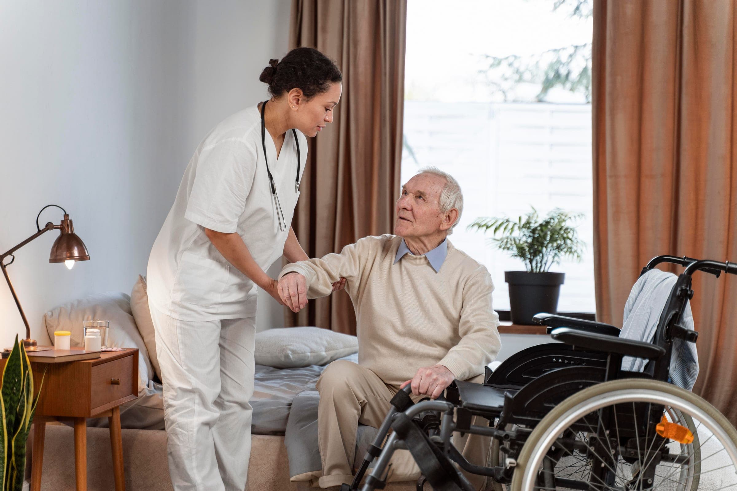 A Hamsa caregiver helping a senior client stand up at home.